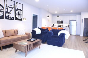 Un salon moderne avec un canapé marron, un canapé bleu et une table basse en bois.