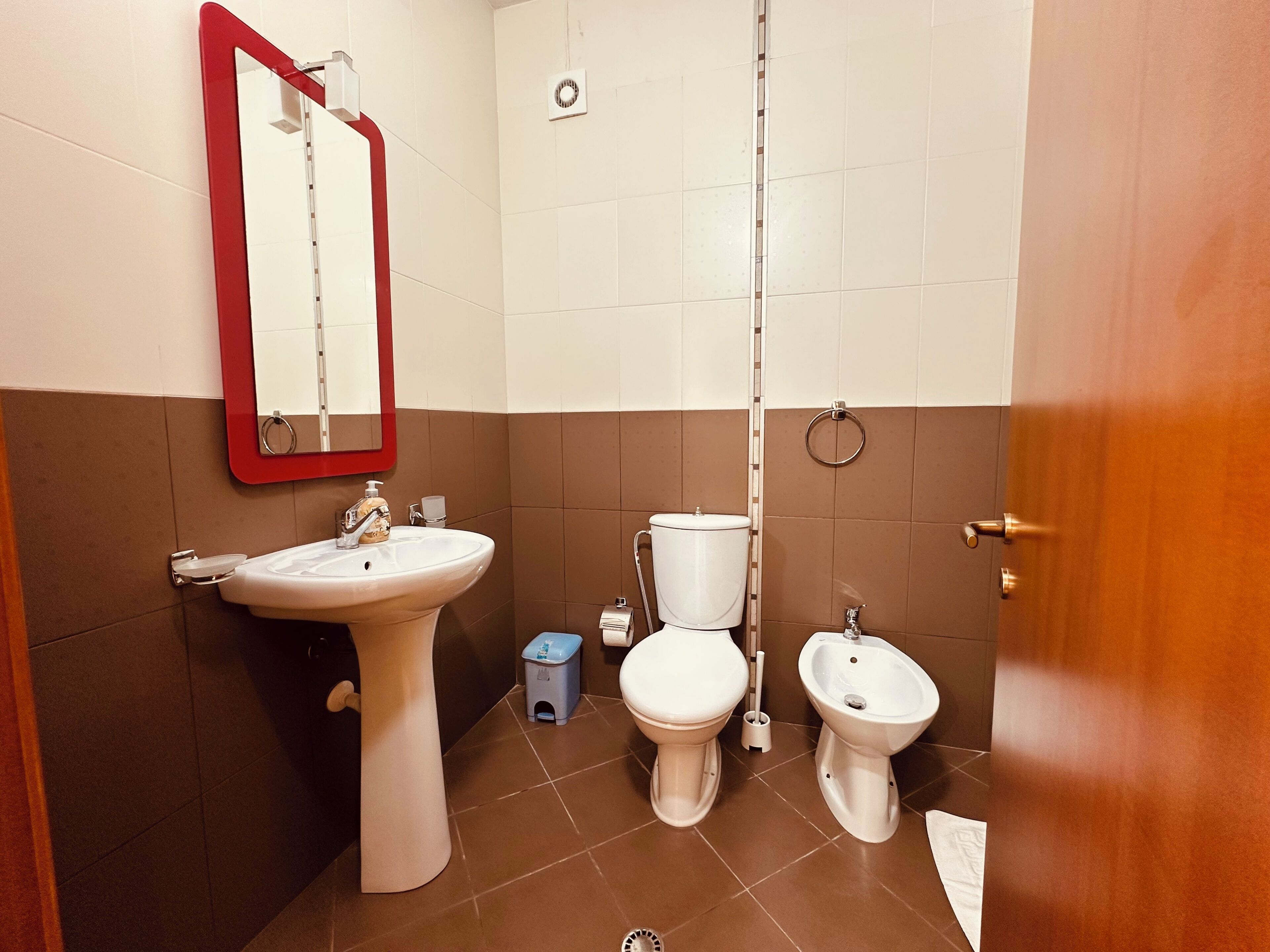 Ein Badezimmer mit Waschbecken, Toilette, Bidet und Spiegel.