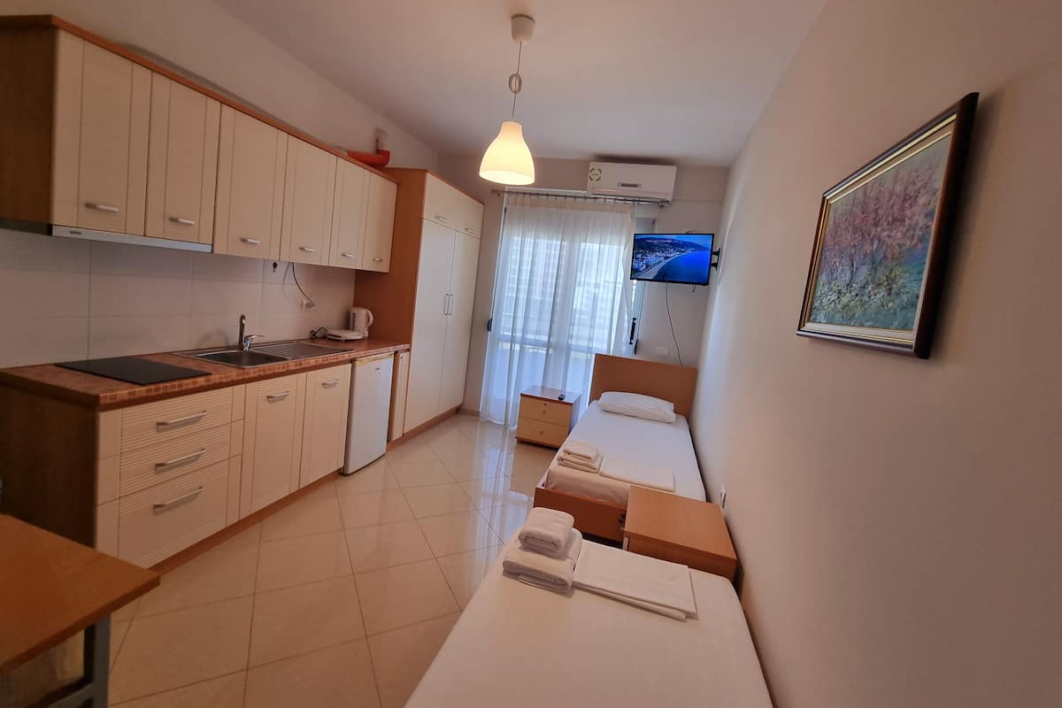 Estudio económico, 2 camas individuales, balcón, vista parcial al mar | Escritorio, wifi gratis y ropa de cama