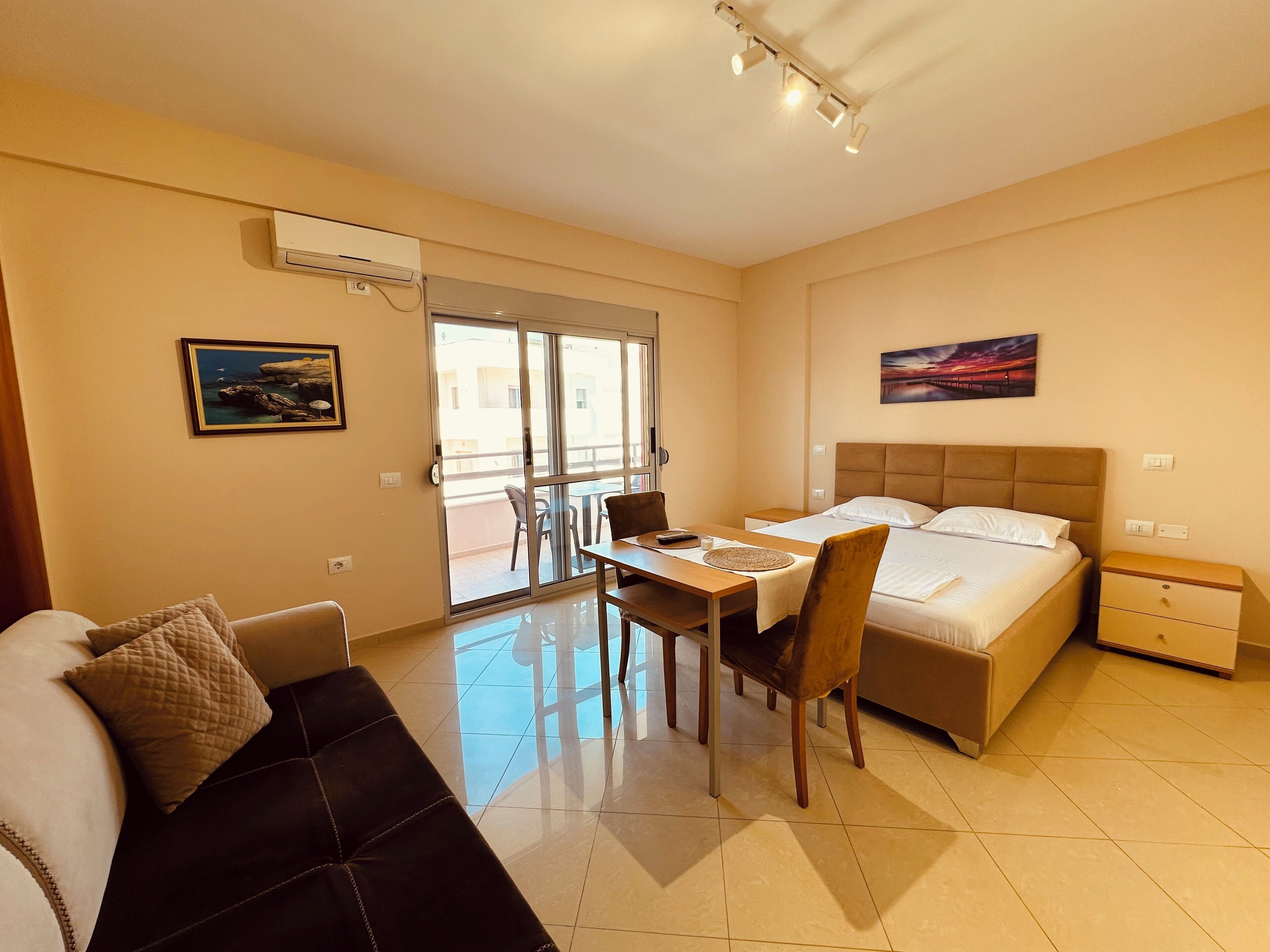 Une chambre d’hôtel comprenant un lit, un bureau, une chaise, un canapé, une table à manger et un balcon.