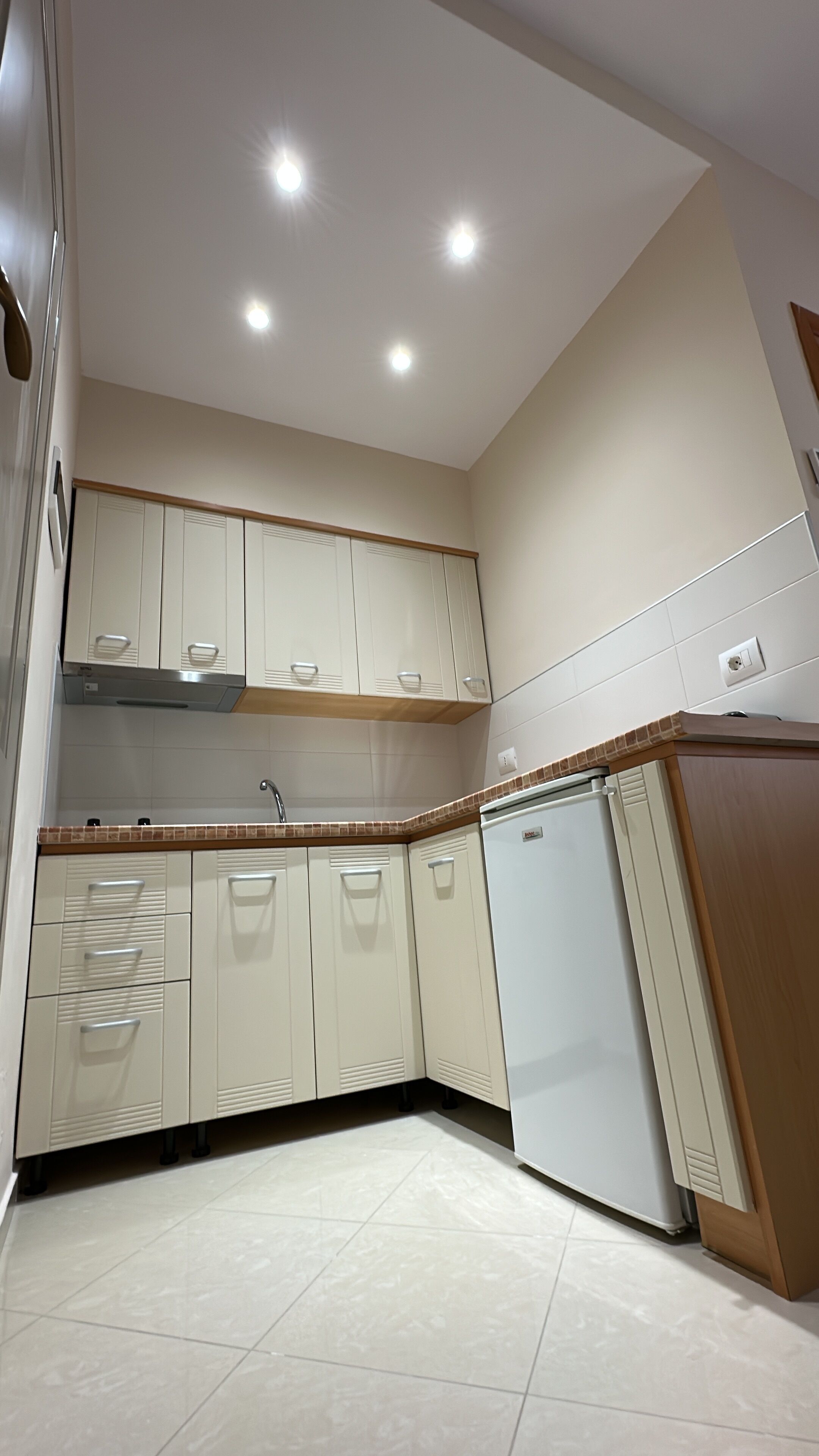A kitchen with white cabinets, a built-in oven, and a tiled backsplash.