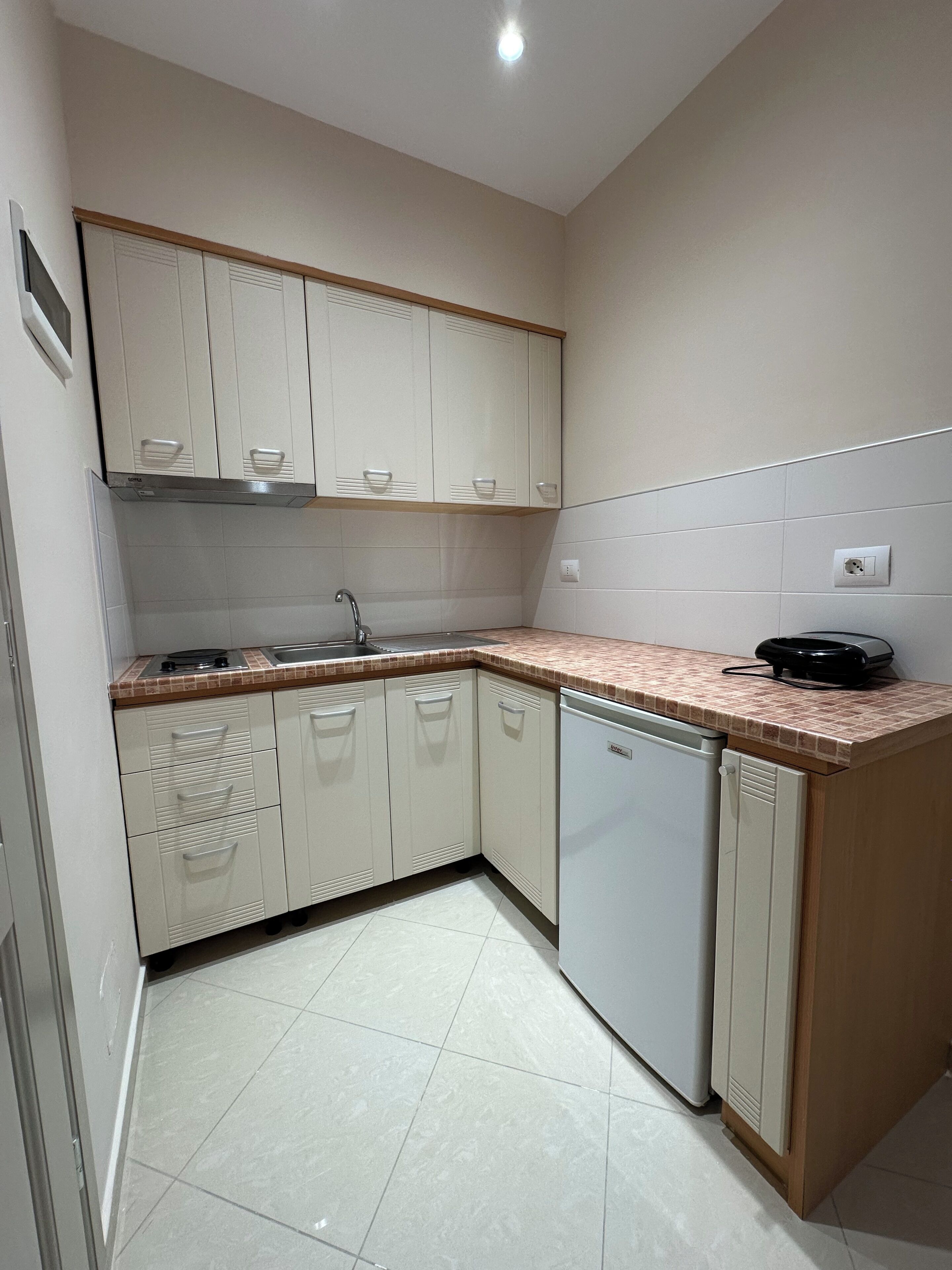 A kitchen with white cabinets, a sink, a stove, and a dishwasher.