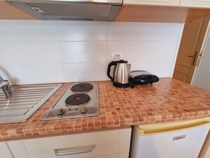 A kitchen with a gas stove, a kettle, and a toaster. - Thoma's K Studios (Vlorë)