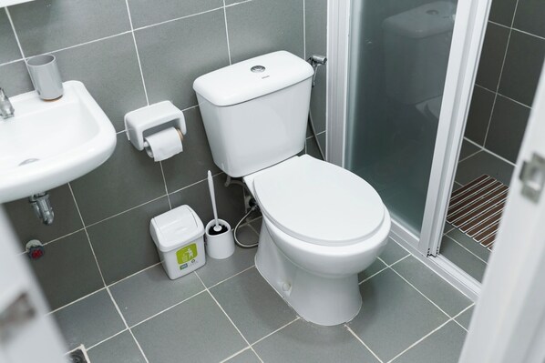 Une salle de bain moderne équipée de toilettes, d’un lavabo et d’une douche.