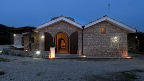 A stone building with a central arched entrance and a small window on the right.