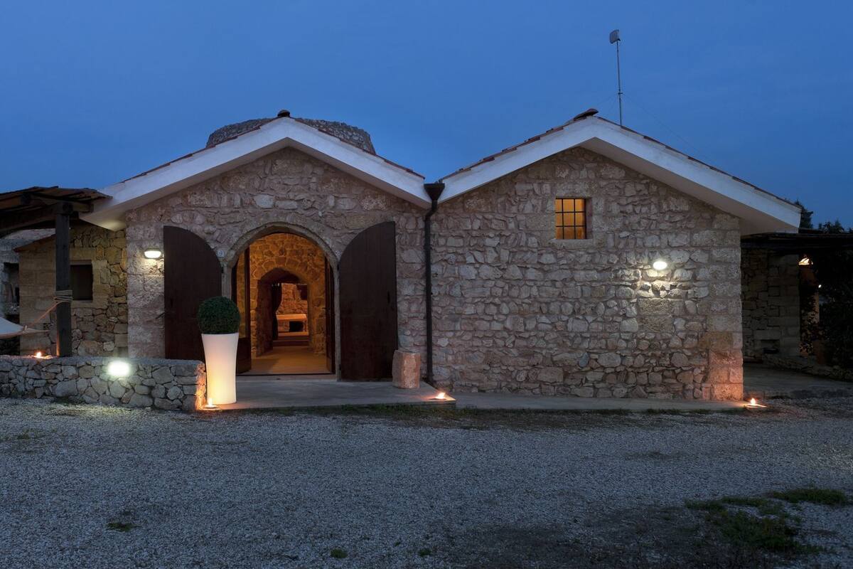 Un bâtiment en pierre doté d’une entrée centrale en forme d’arc et d’une petite fenêtre sur le côté droit.