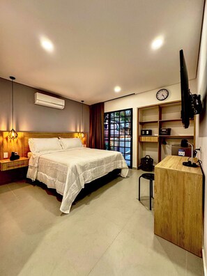 A hotel room with a bed, bedside tables, a desk, a chair, a TV, a clock, and a window with curtains. - Hotel Boutique - Light (Medellín)