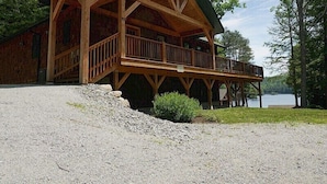 A wooden cabin with a balcony, situated by a lake. - Come stay at our four season resort! (Weare)