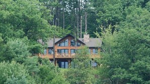 A large, multi-story wooden cabin surrounded by dense forest. - Come stay at our four season resort! (Weare)