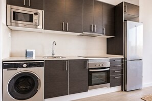 Eine moderne Küche mit Edelstahlgeräten, darunter eine Mikrowelle, ein Geschirrspüler, ein Backofen und ein Kühlschrank.