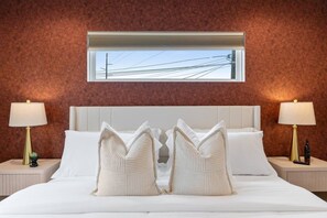 A hotel room with a large bed, two bedside tables, and a window with a view of power lines. - Modern 3BR Home | 5 Min to Downtown & SXSW (Austin)