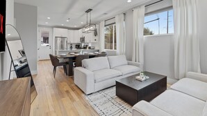 Un salon moderne avec un canapé, une table basse et un coin repas.