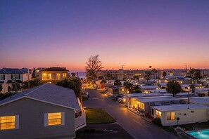A residential area with houses and a swimming pool. - Entire 6BR Beach Duplex | Walk to Beach | Sleeps 12 (Bradenton Beach)
