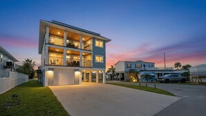 A multi-story residential building with a covered front porch and a garage. - Entire 6BR Beach Duplex | Walk to Beach | Sleeps 12 (Bradenton Beach)
