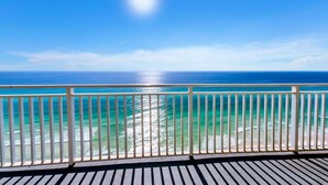 A balcony with a view of the ocean and a clear sky.