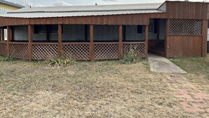 A single-story building with a covered porch and a fenced outdoor area.
