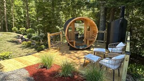 Eine Holzhütte mit rundem Innenraum, einer Terrasse und Sitzgelegenheiten im Freien.