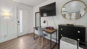 A modern room with a desk, chair, and a flat-screen TV mounted on the wall. - Chic City Retreat 97 Sleeps 2! (Columbus)