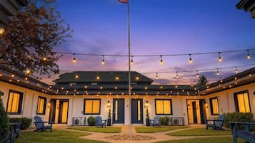 Un hôtel doté d’un mât pour drapeau, de guirlandes lumineuses et de sièges en plein air.