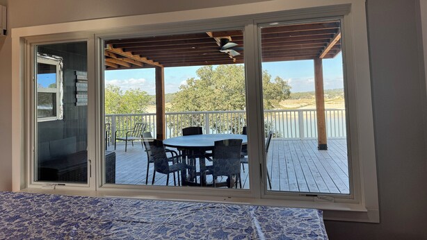 A room with a large window overlooking a deck with outdoor furniture.