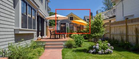 A residential backyard with a patio, outdoor furniture, and a garden.