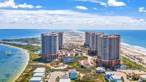A coastal hotel complex with multiple high-rise buildings, a beachfront, and a clear view of the ocean.