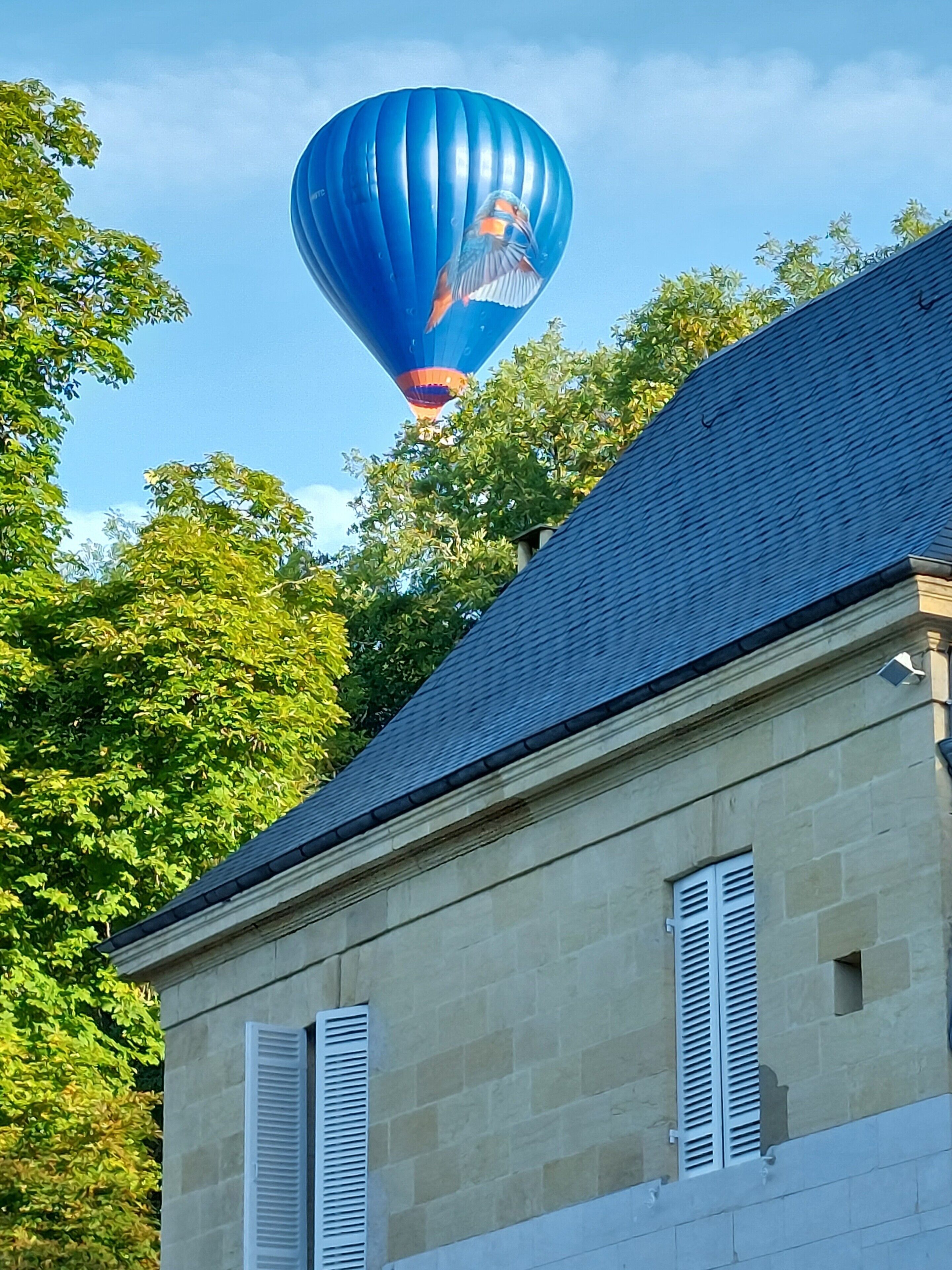 Ein Gebäude mit einer Steinauffahrt, weißen Fensterläden und einem geneigten Dach.