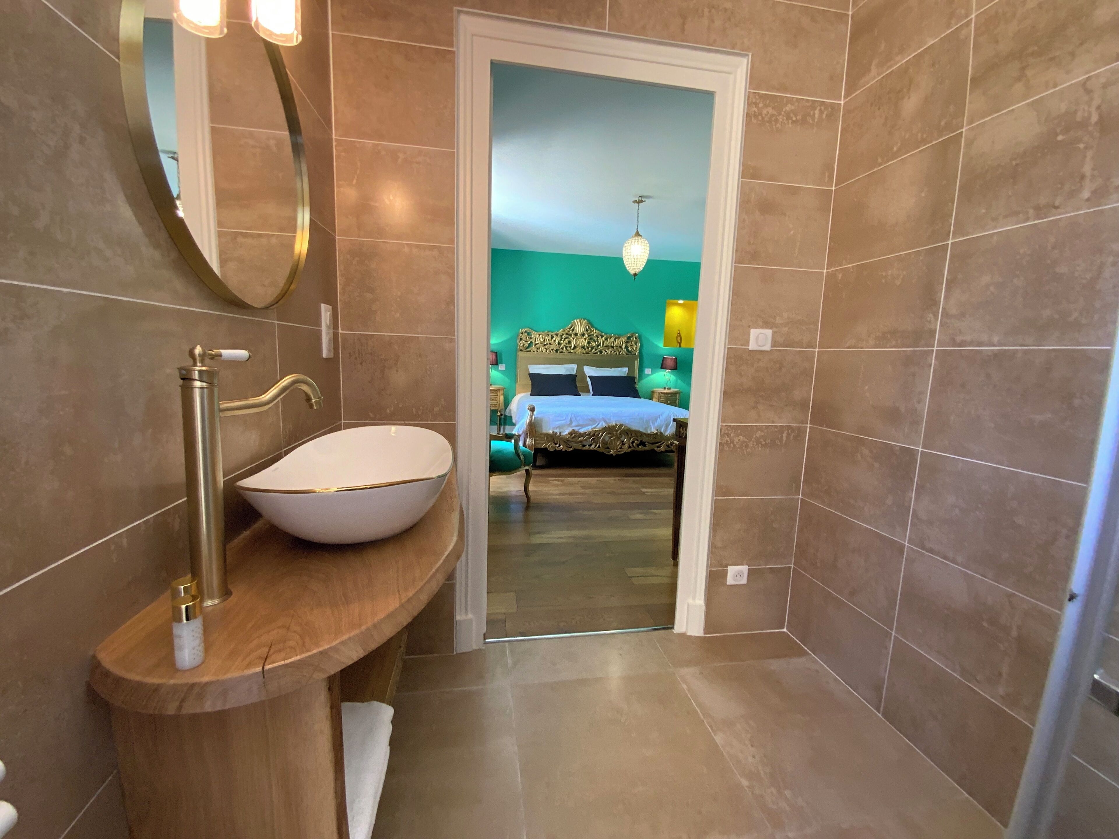 A bathroom with a large oval sink, a mirror, and a wooden vanity.