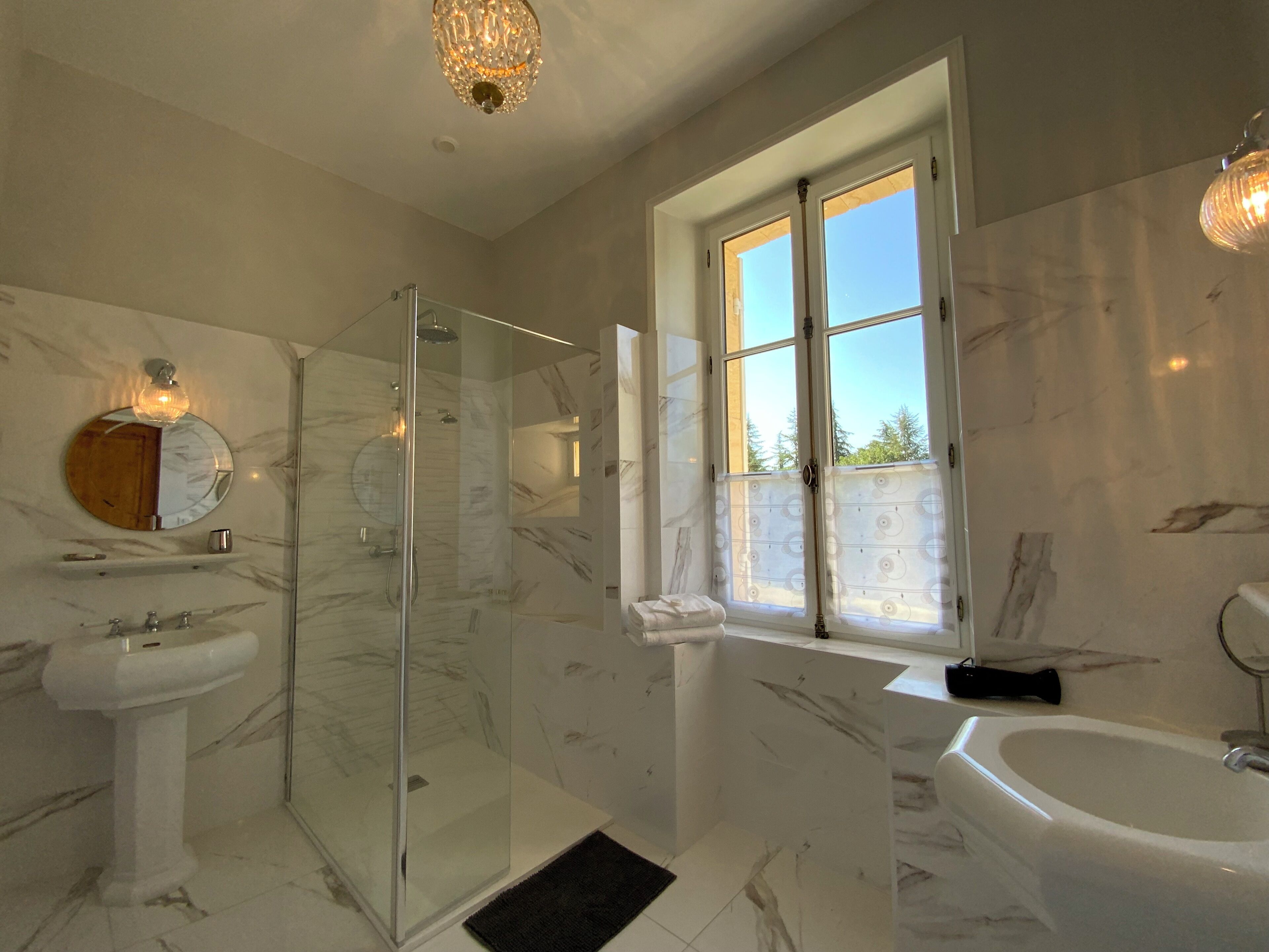 Ein modernes Badezimmer mit einer Duschkabine, einem Standwaschbecken und einer Badewanne.