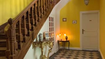 A staircase with wooden balusters leading to a landing with a checkered floor.