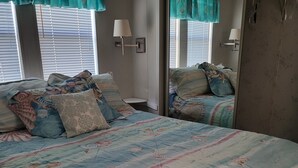 Une chambre à coucher avec un grand lit, deux lampes de chevet et un miroir.