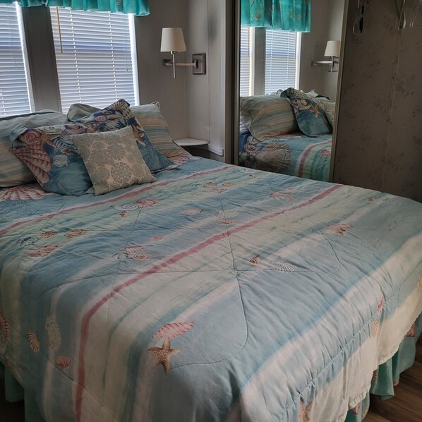 A bedroom with a large bed, two bedside lamps, and a mirror. - Cozy mobile home in charming Sarasota with fitness room, WiFi (Sarasota)