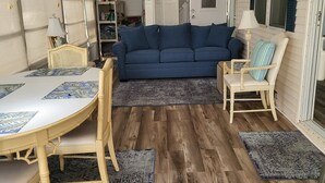 Un salon chaleureux avec un canapé bleu, des meubles en bois et un tapis à motifs.
