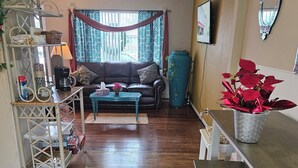 Un salon comprenant un canapé, une table basse et un coin repas avec des chaises et une table.
