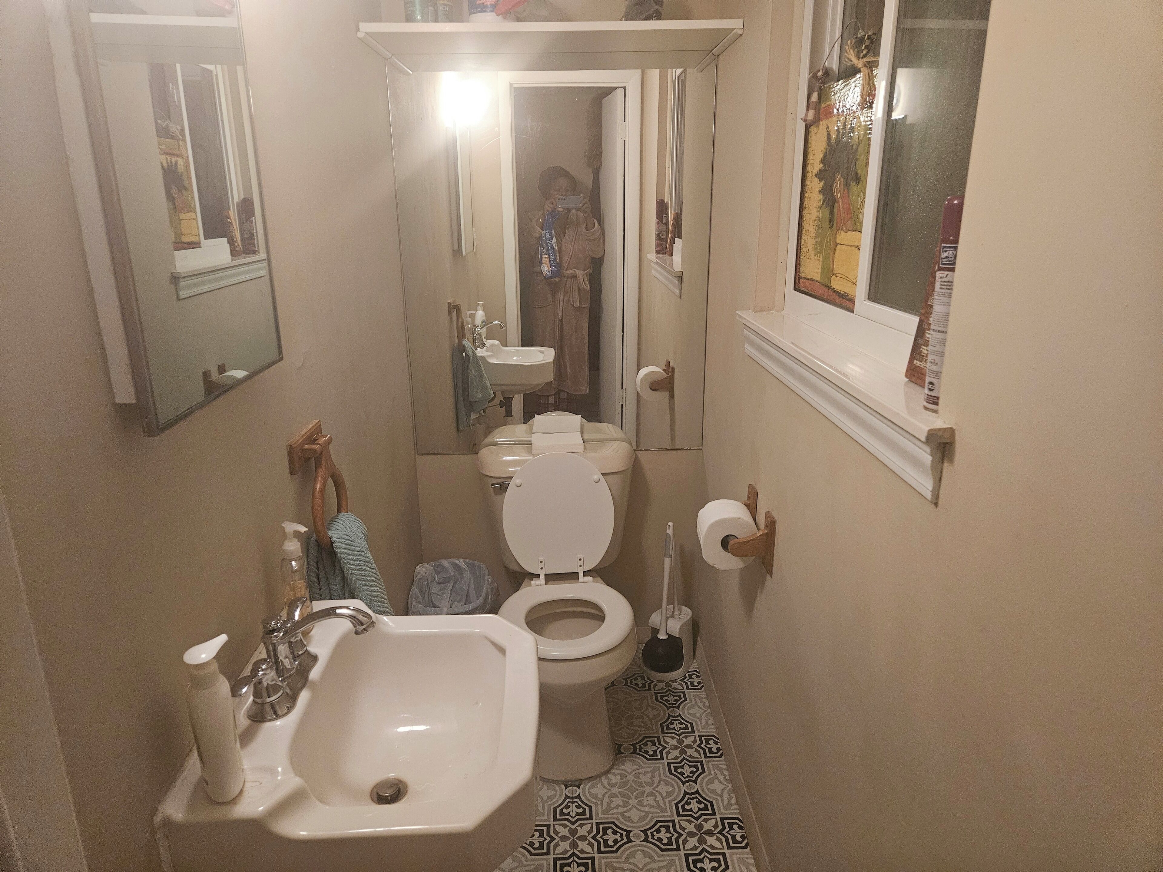 A compact bathroom with a sink, toilet, and mirror.