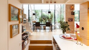 A modern interior with a dining area, bookshelves, and artwork.