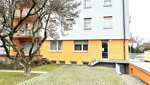 A multi-story residential building with a yellow facade and white windows. - Hotel Soad (Salach)
