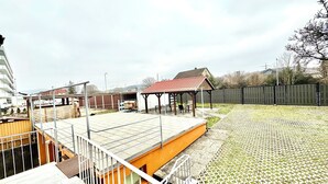 A rooftop terrace with a covered seating area, a swimming pool, and a fenced garden. - Hotel Soad (Salach)