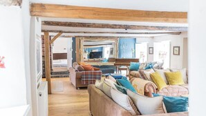 A cozy living room with a wooden ceiling, a sofa set, and a television. - Stunning Character Property with Hot tub (kendal)