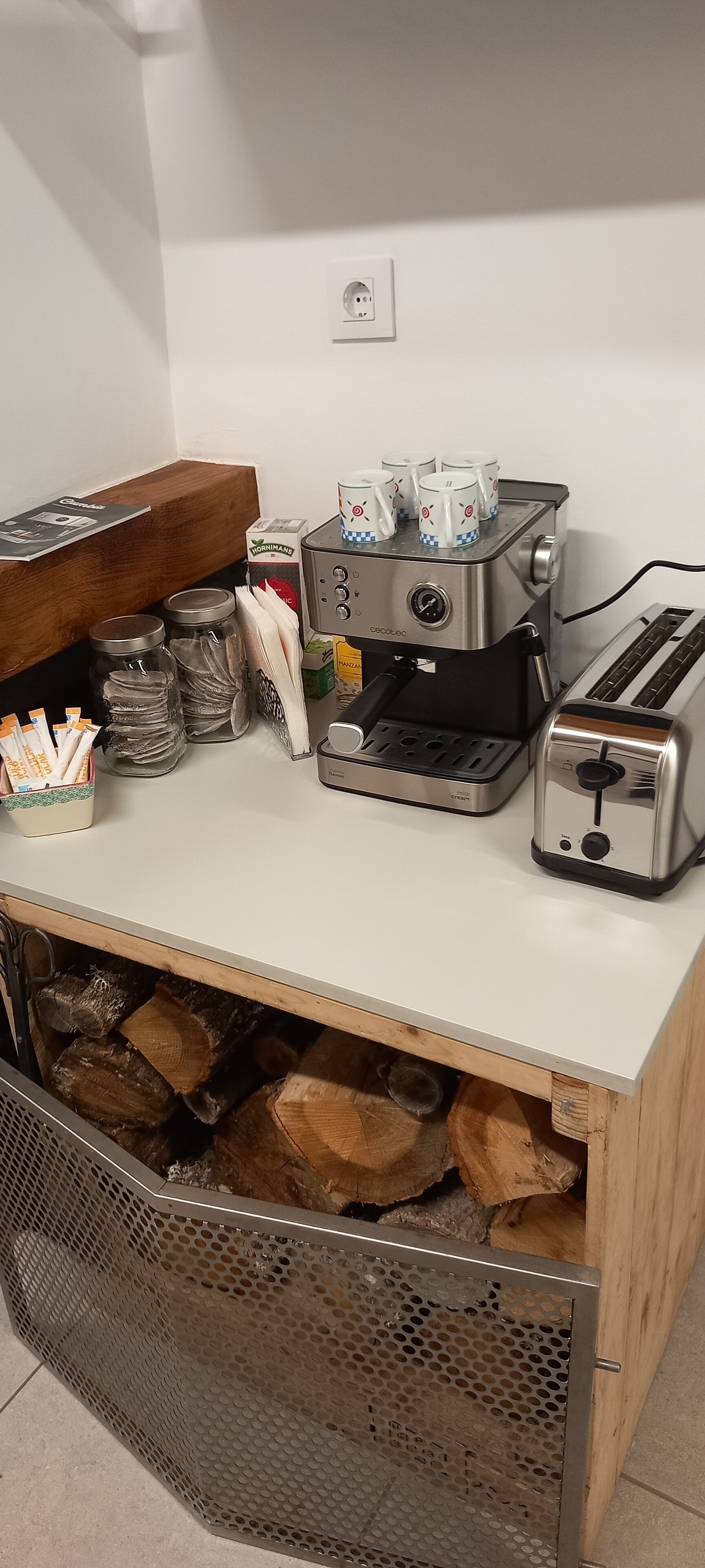 Een keuken met een koffieapparaat, een broodrooster en opslagpotten.