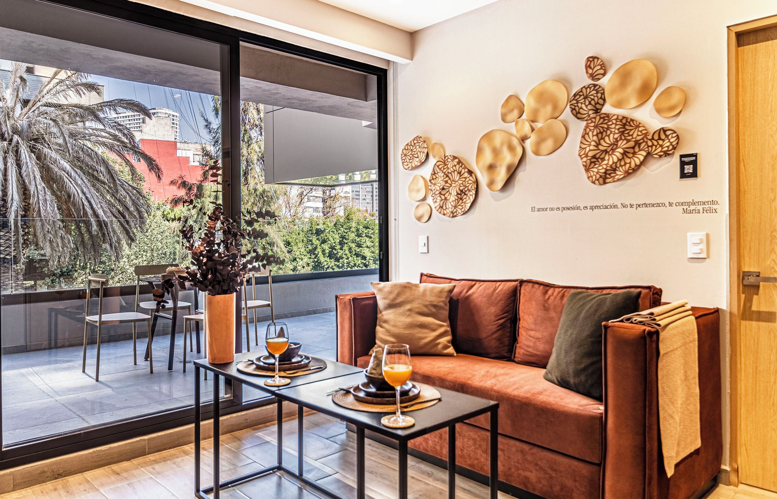 A modern living room with a large window, a sofa, a coffee table, and decorative wall art.