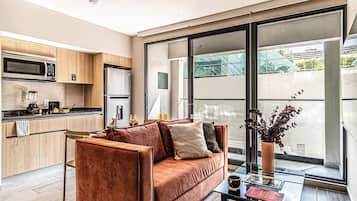 Premier Apartment, Balcony, City View | Living area | 50-inch Smart TV with cable channels