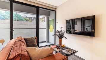 Apartamento premier, sacada, vista para a cidade | Área de estar | Smart TV 50 polegadas com canais a cabo