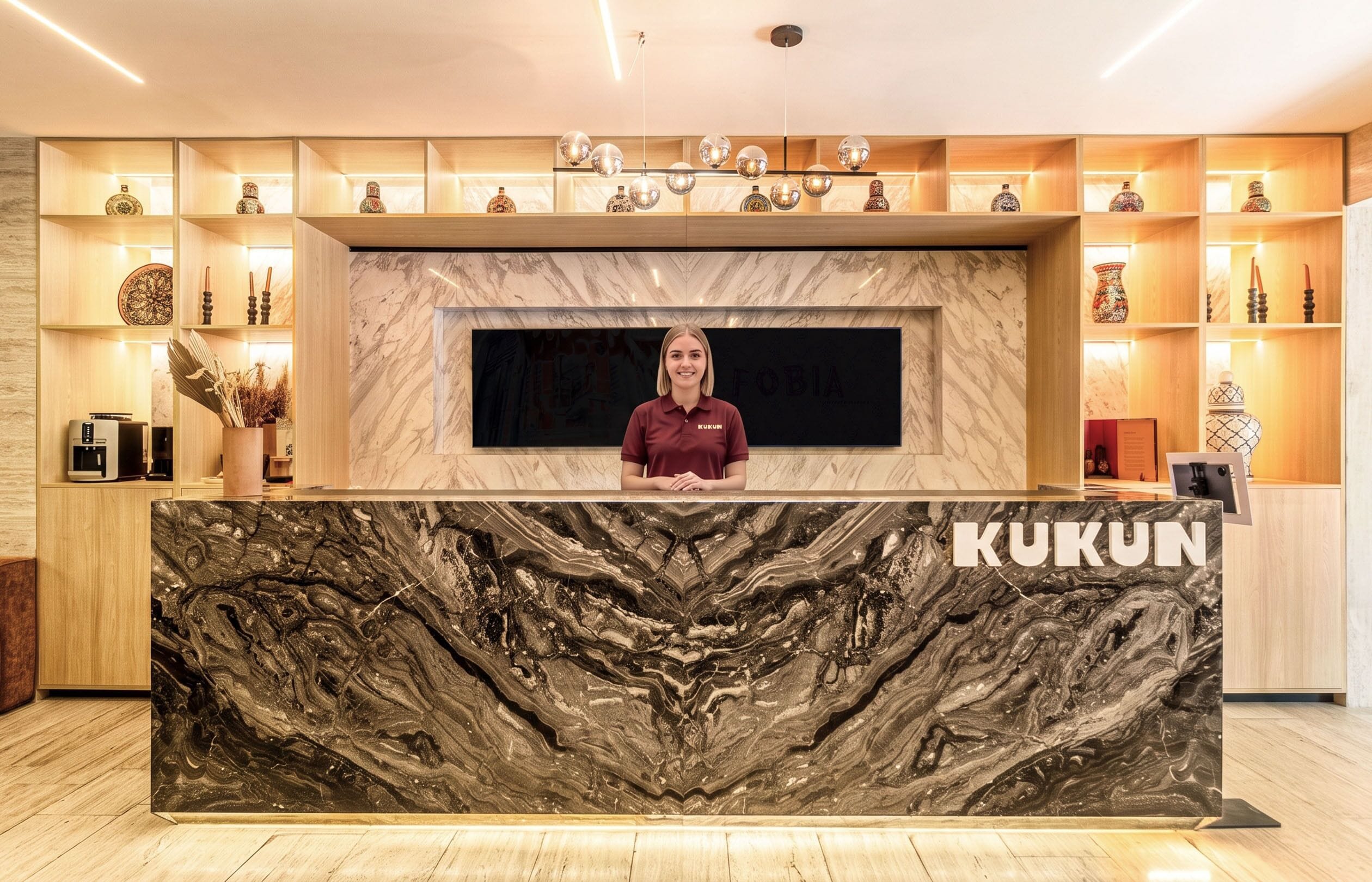 Una mesa de recepción con cubierta de mármol y el nombre 'KUKUN' visible.