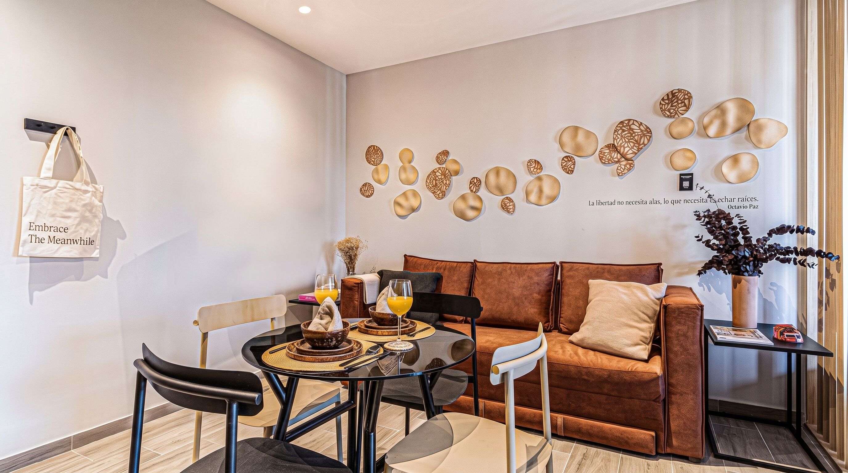 En moderne stue med en brun sofa, et glasbord og et spiseområde med stole og et lille bord.