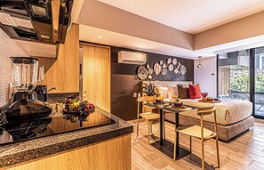Una cocina moderna con estufa integrada, cafetera y frutero.