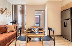 Una cocina moderna con una mesa de comedor, sillas y un refrigerador.