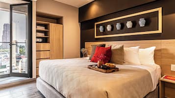 Een moderne slaapkamer met een groot bed, een houten garderobe, een nachtkastje en uitzicht op de stad door een glazen deur.