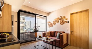 Departamento exclusivo, balcón, vista a la ciudad | Área de sala de estar | Smart TV de 50 pulgadas con canales por cable 