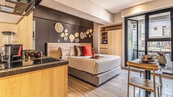 Une chambre moderne comprenant un lit, une table de chevet et un coin repas avec une table et des chaises.